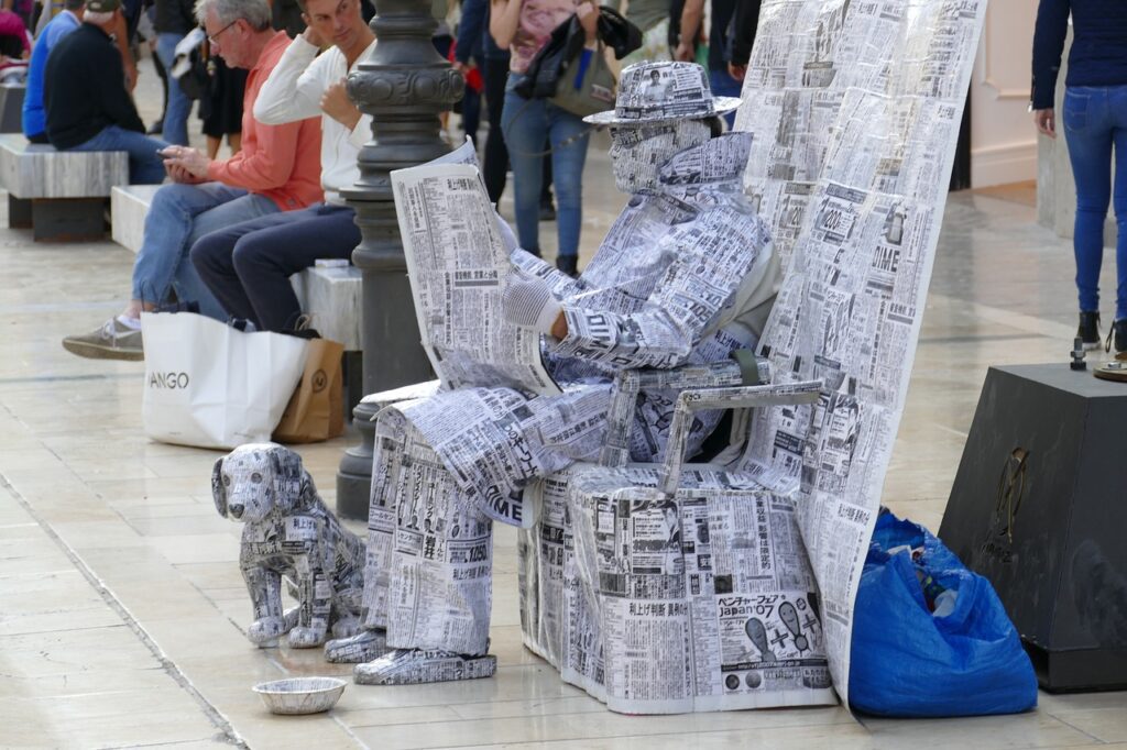 writing man covered completely in newspapers