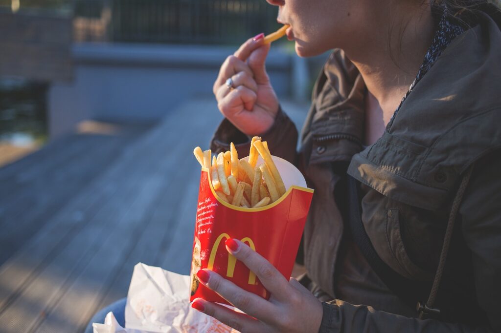 woman eating McDonald's fries; company reflects trends writing