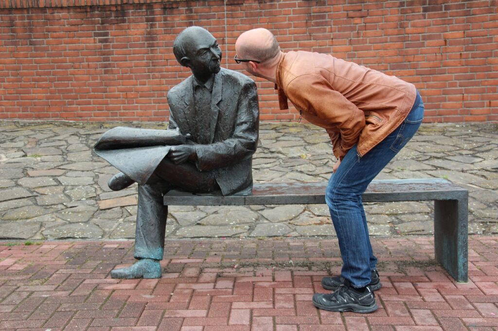 man looking at a statue; they look like they are engaged in dialogue